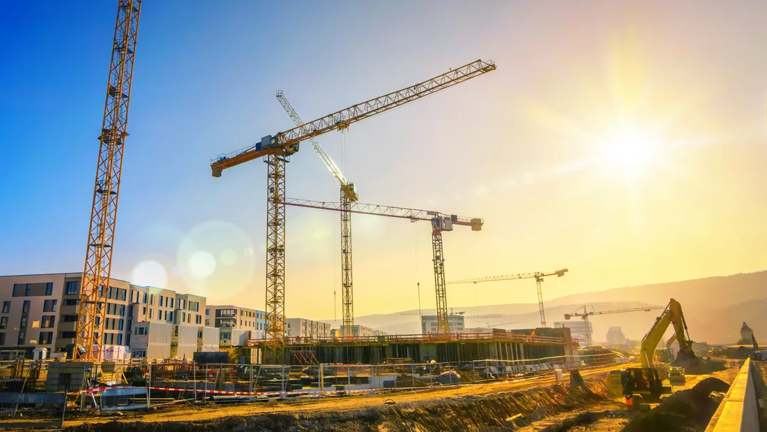 Tower cranes on a construction site at sunset
